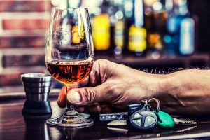Cup cognac whiskey or brandy hand man the keys to the car and irresponsible driver.