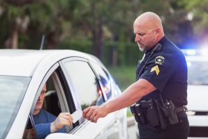 Driver pulled over by police, giving ID to officer