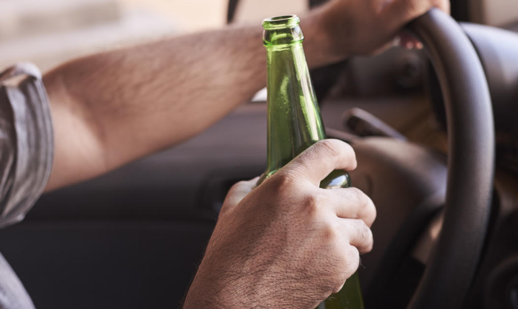 Motorist drinking while behind the wheel.